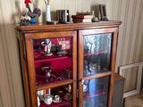 a cabinet with a glass door and a vase on top of it