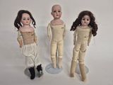 three dolls standing next to each other on a white surface