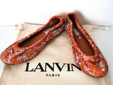 des chaussures Lanvin dans un sac et une paire de chaussures orange