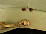 a green hat with a gold button on it
