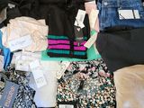 une valise pleine de vêtements et des vêtements qui traînent par terre