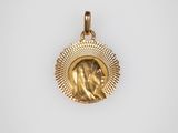 un pendentif en or représentant une femme entourée d'un halo de rayons de soleil