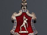 an image of a red and silver badge with a man on it