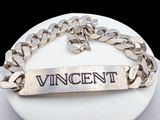 un bracelet en argent sur lequel est gravé le mot « Vincent »