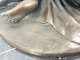 a bronze statue of a woman holding a baby