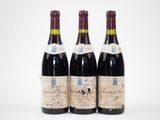 trois bouteilles de vin sont posées sur une surface blanche
