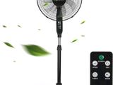 un ventilateur noir posé sur un trépied, à côté d'une télécommande