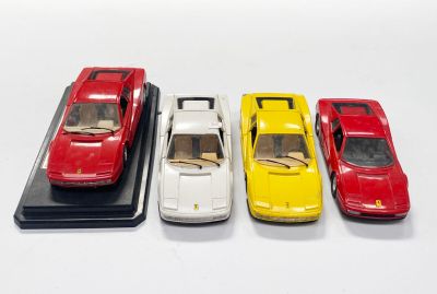 quatre petites voitures sont alignées sur une surface blanche