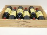 six bottles of wine in a wooden box on a table