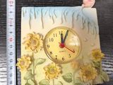 a clock that is sitting on a table next to a ruler