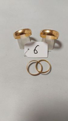 deux alliances en or et une bague avec une étiquette de prix