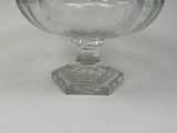a glass bowl on a pedestal on a white surface