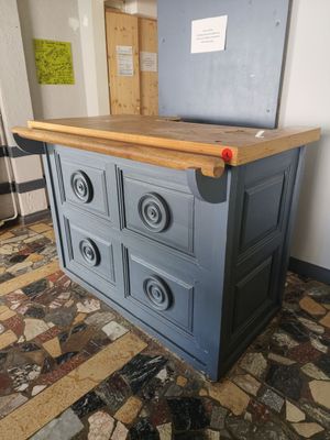 une armoire bleue avec des tiroirs et un plan de travail en bois