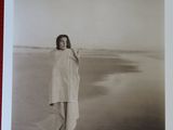 photographie en noir et blanc d'une femme debout sur une plage