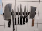 five knives hanging on a wall in a kitchen