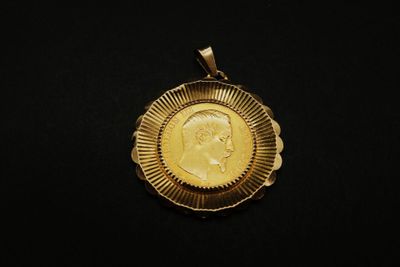 gros plan d'une pièce d'or sur une surface noire