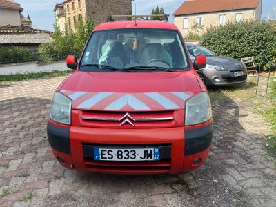 a small red car parked on the side of the road