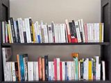 une étagère contenant de nombreux livres dans une pièce