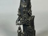 une image représentant un vase noir sur lequel est posée une statue