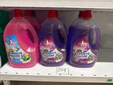 three bottles of liquid on a shelf in a store