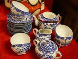 a red table with blue and white dishes and cups on it