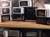 de nombreux micro-ondes posés sur une étagère dans une pièce