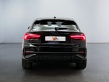 the rear end of a black car in a white room