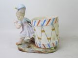a figurine of a little girl with a drum