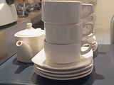 une pile de tasses et de soucoupes posée sur un comptoir