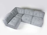 Canapé modulable gris avec méridienne et pouf sur fond blanc