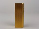 a gold lighter sitting on top of a white surface