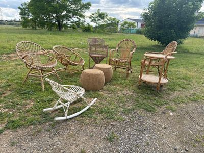 several wicker chairs and a rocking chair in a grassy area