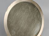 a mirror that is on a stand on a gray background