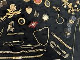a lot of gold jewelry on a black table