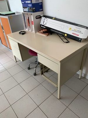un bureau sur lequel est posée une imprimante, dans une pièce