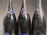 trois bouteilles de champagne sont alignées sur une table