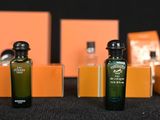three bottles of olive oil sitting on a table next to orange boxes