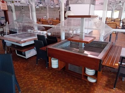 tables and chairs in a restaurant with a glass display case on top