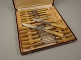 plusieurs couteaux dans un coffret en bois posé sur une table