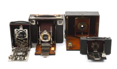 Plusieurs appareils photo anciens sont alignés en rangée sur une surface blanche