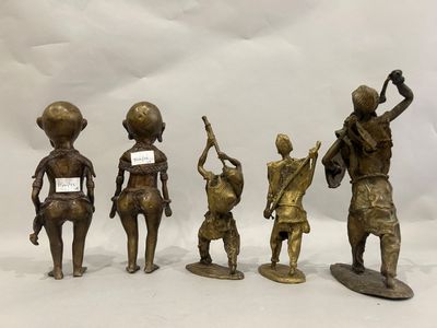 four bronze figurines of people with a sign in their hands