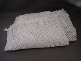 a white crocheted cloth on a black table