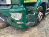 a green truck with a yellow stripe on the front of it