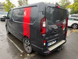 a black van with red stripes parked in a parking lot