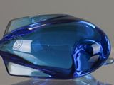 a blue glass object sitting on top of a glass table