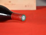 a bottle of wine sitting on a red table cloth