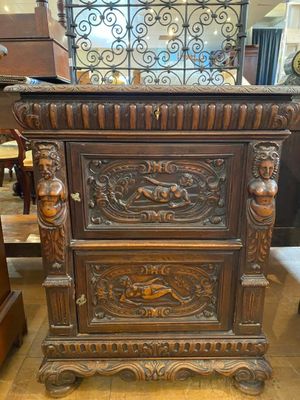 an antique wooden cabinet with ornate carvings on top of it