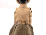 Le mannequin porte une robe marron et un chapeau de paille.