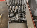 many drill bits in a metal case on a table