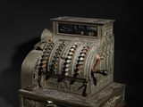 an old fashioned cash register sitting on top of a black surface